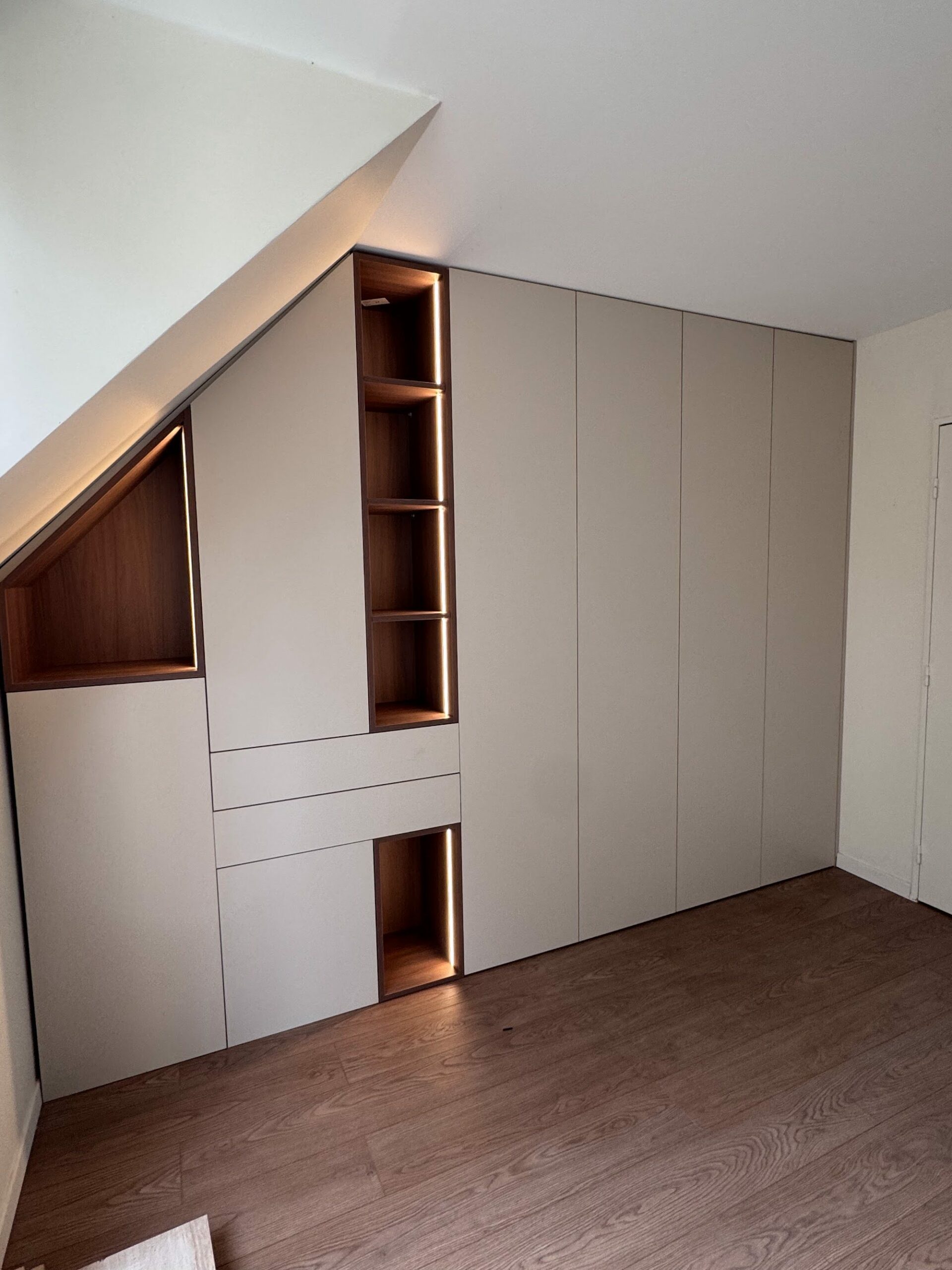 Dressing sur mesure sous pente avec niches en bois éclairées