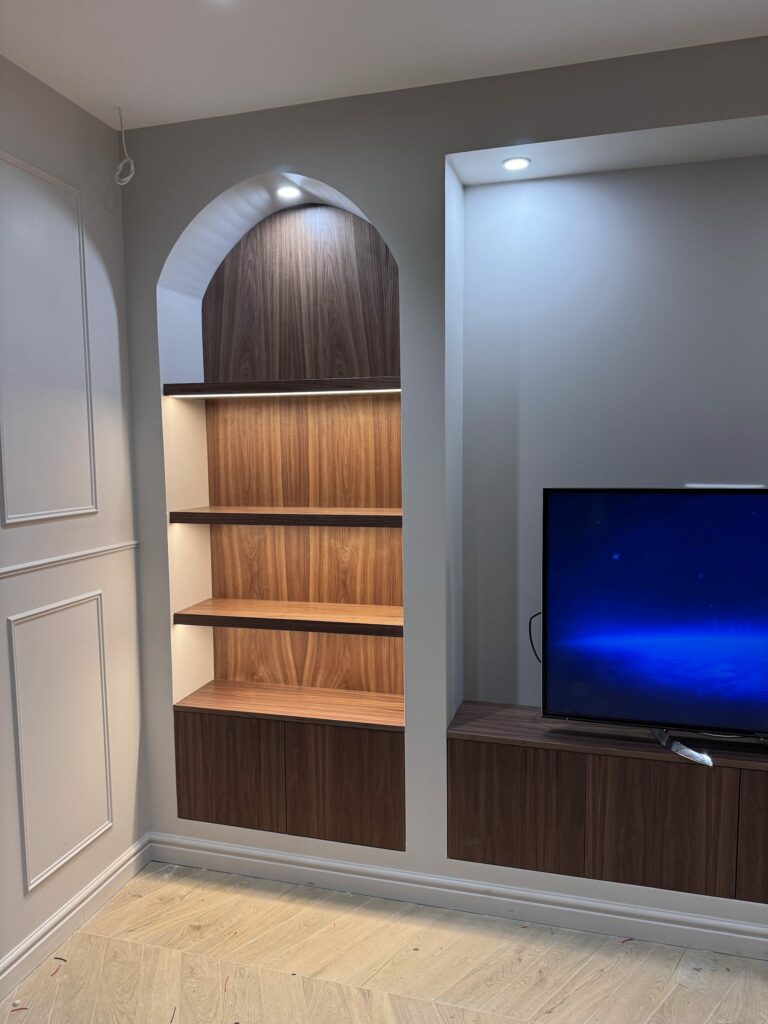 Meuble TV et bibliothèque sur mesure dans une niche cintrée