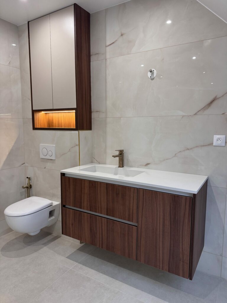 Meuble de salle de bain suspendu en noyer et mur effet marbre